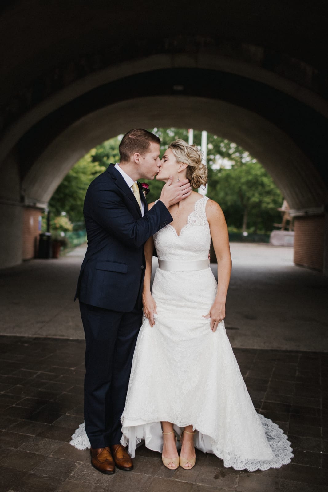 bride and groom kiss while she holds her dress at The Monastery Wedding - Cincinnati Wedding Photographer