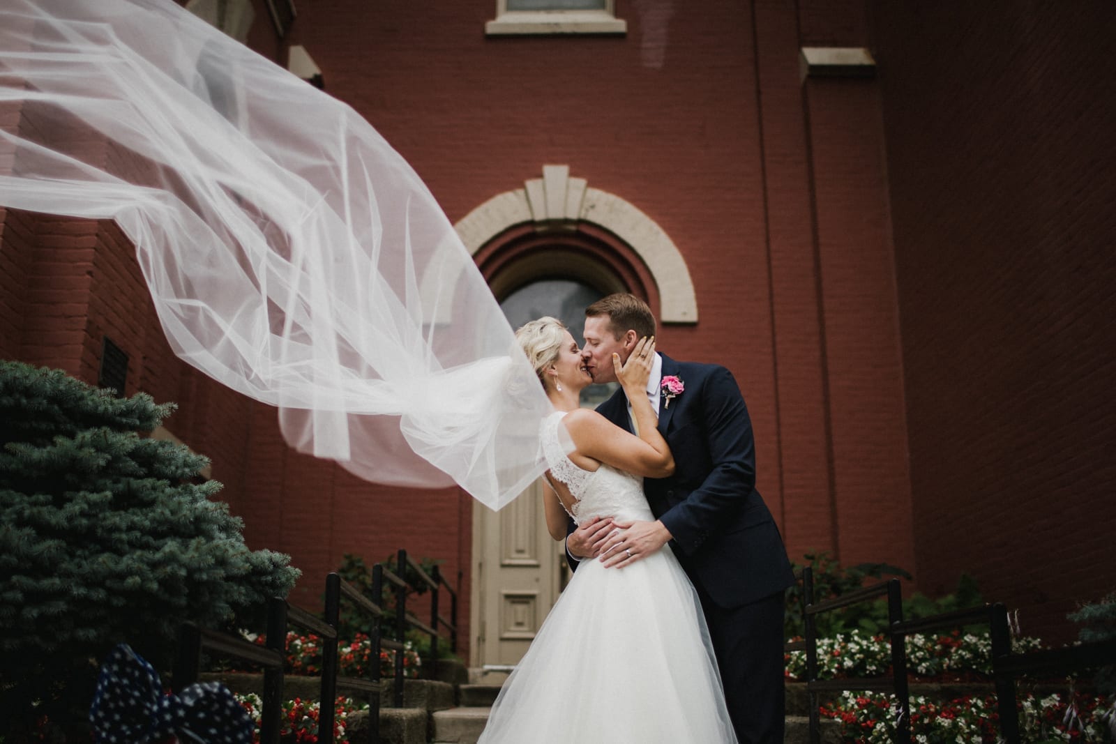 couple kisses while veil blows at The Monastery Wedding - Cincinnati Wedding Photographer