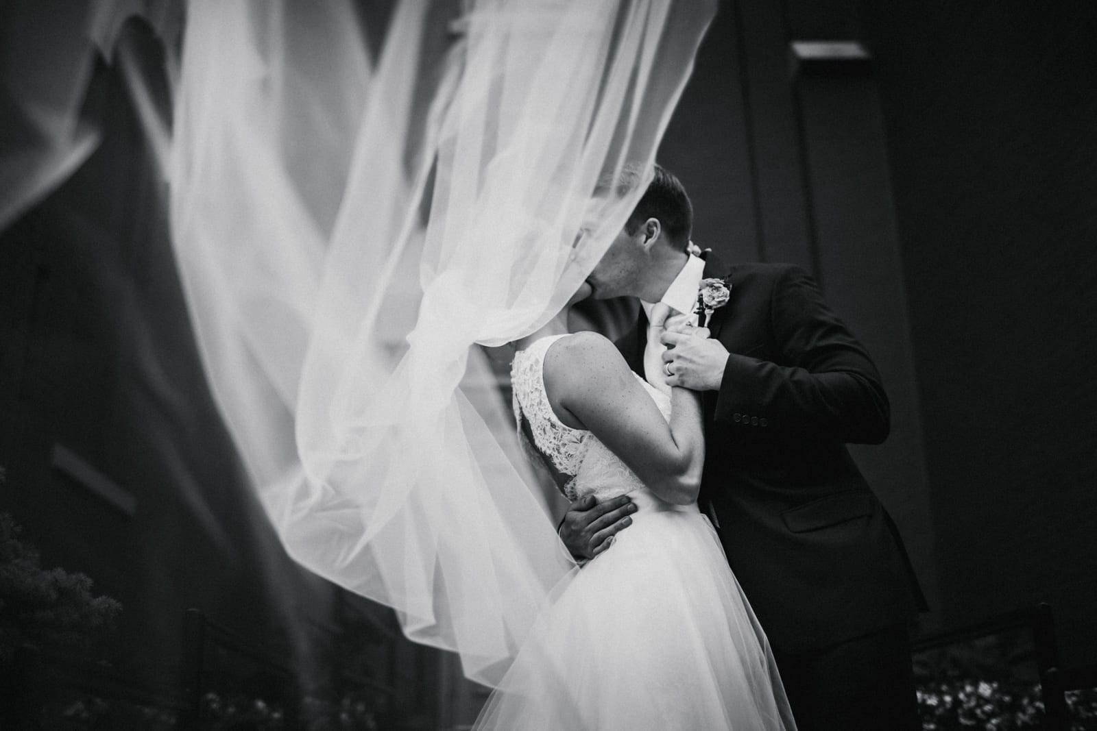 couple kisses while veil blows at The Monastery Wedding - Cincinnati Wedding Photographer