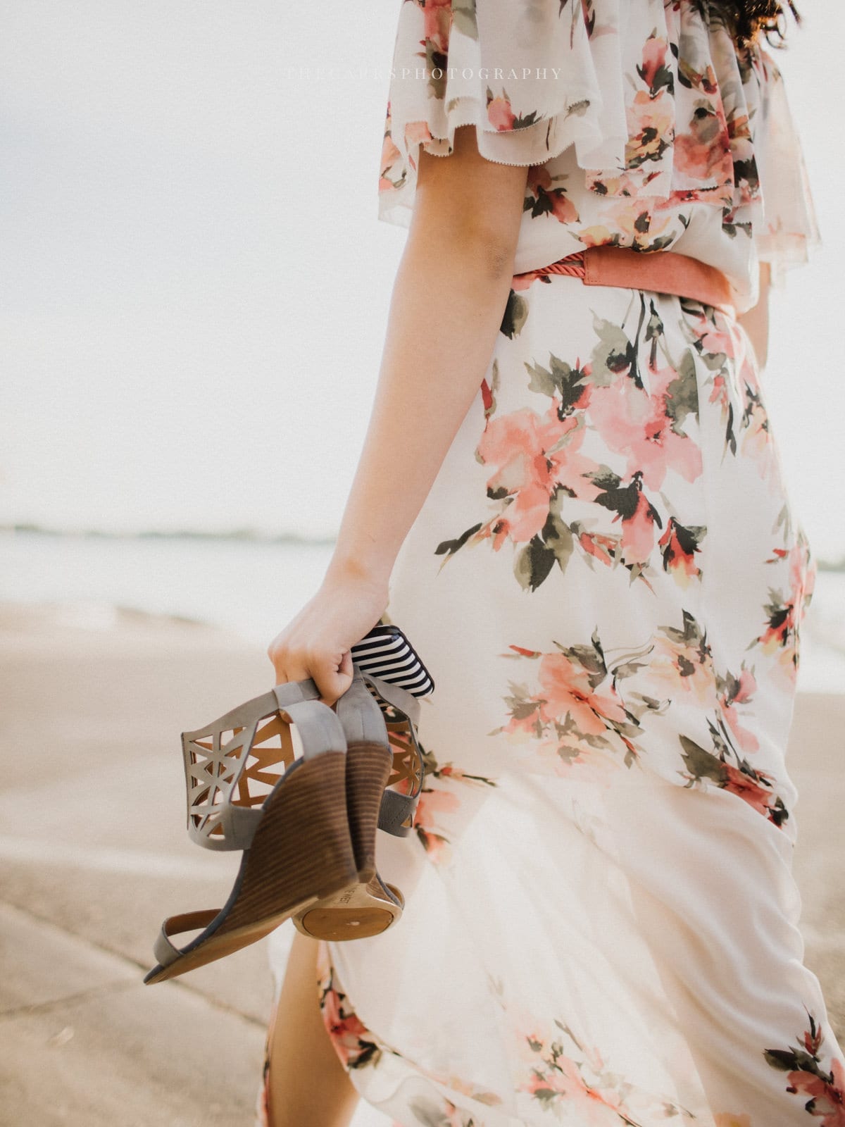 woman walks on sand holding shoes at Minneapolis Engagement Session - Destination Photographer