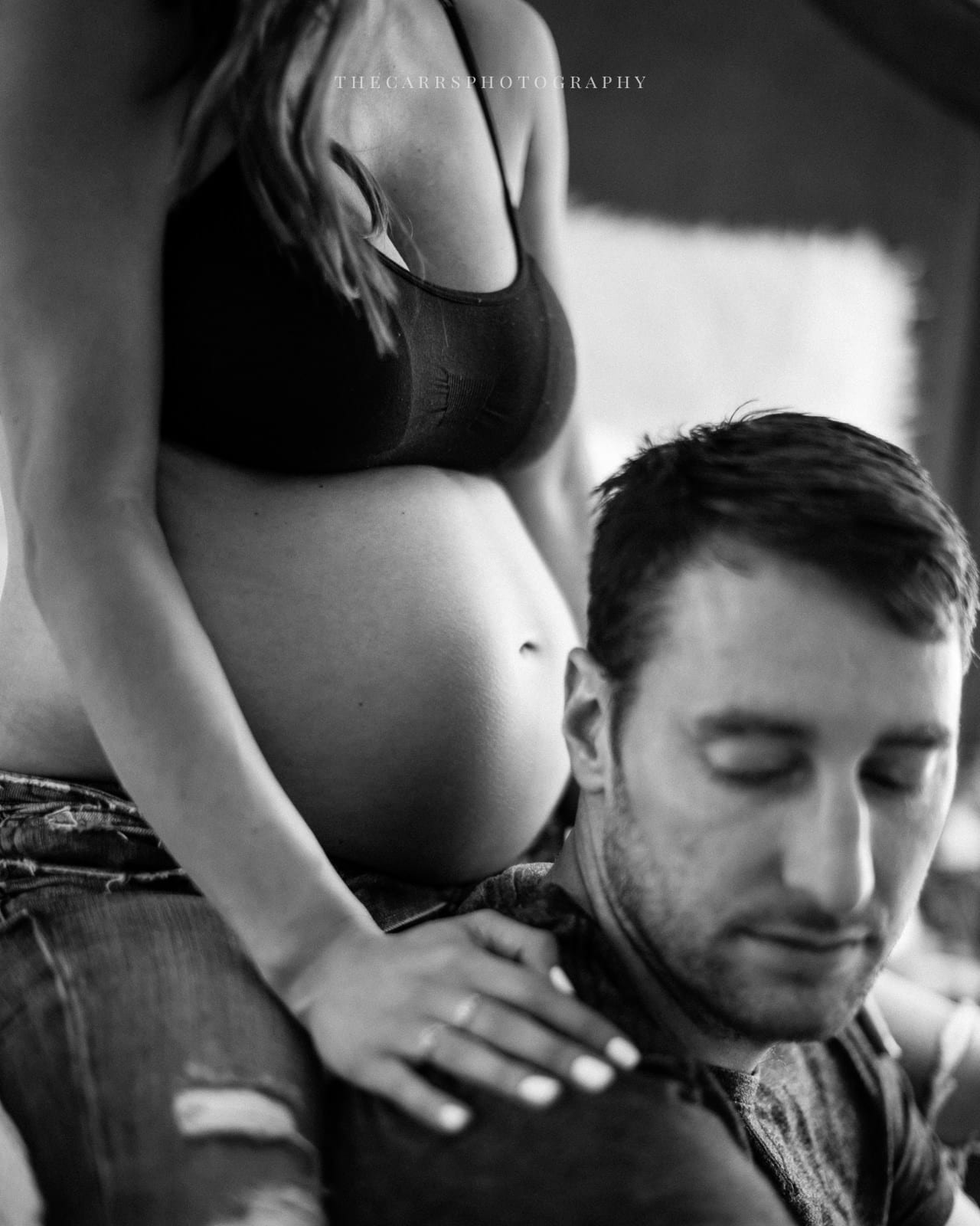 black and white photo of husband's head and wife's belly - cleveland maternity photographer in-home maternity session