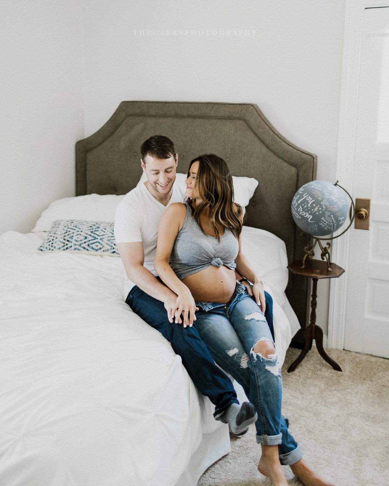 husband and wife lay in bed- cleveland maternity photographer in-home maternity session