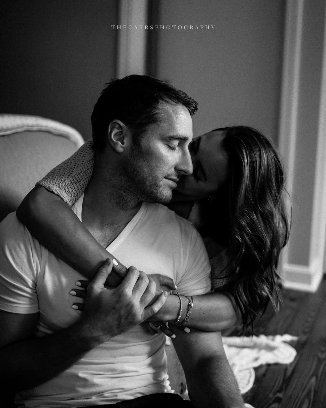 wife kisses husband on cheek - cleveland maternity photographer in-home maternity session