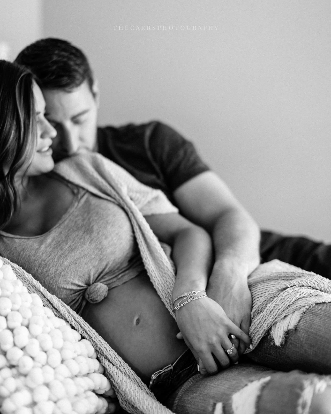 mom and dad lay on bed - cleveland maternity photographer in-home maternity session