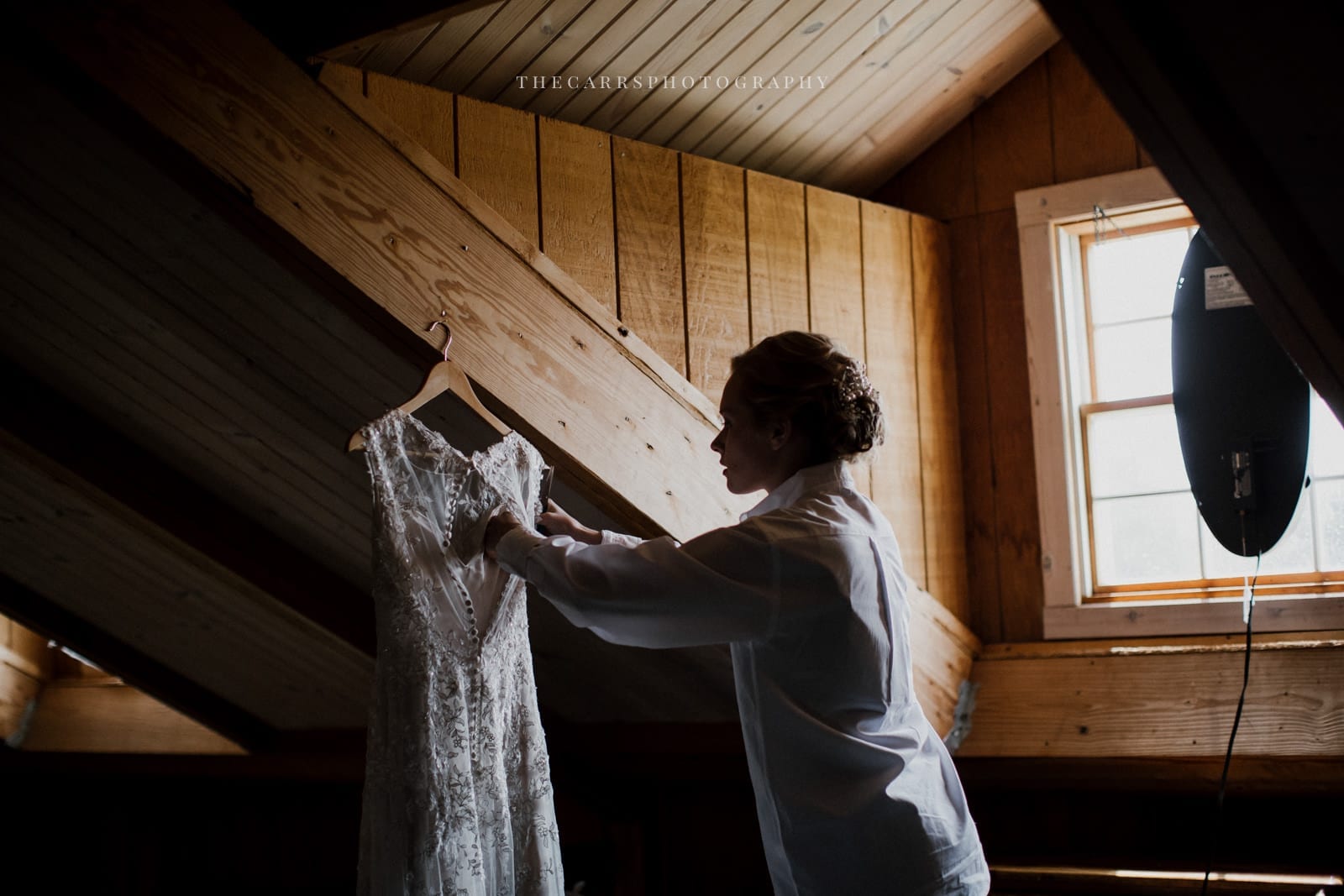 bride fixing dress on hanger at Eckers Apple Farm Wedding - Destination Photographer