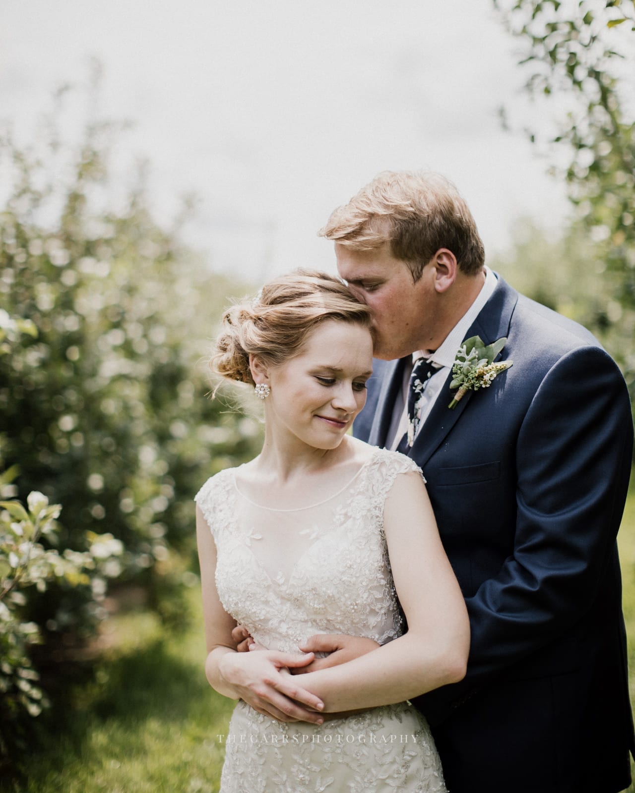 groom kisses bride's head at Eckers Apple Farm Wedding - Destination Photographer