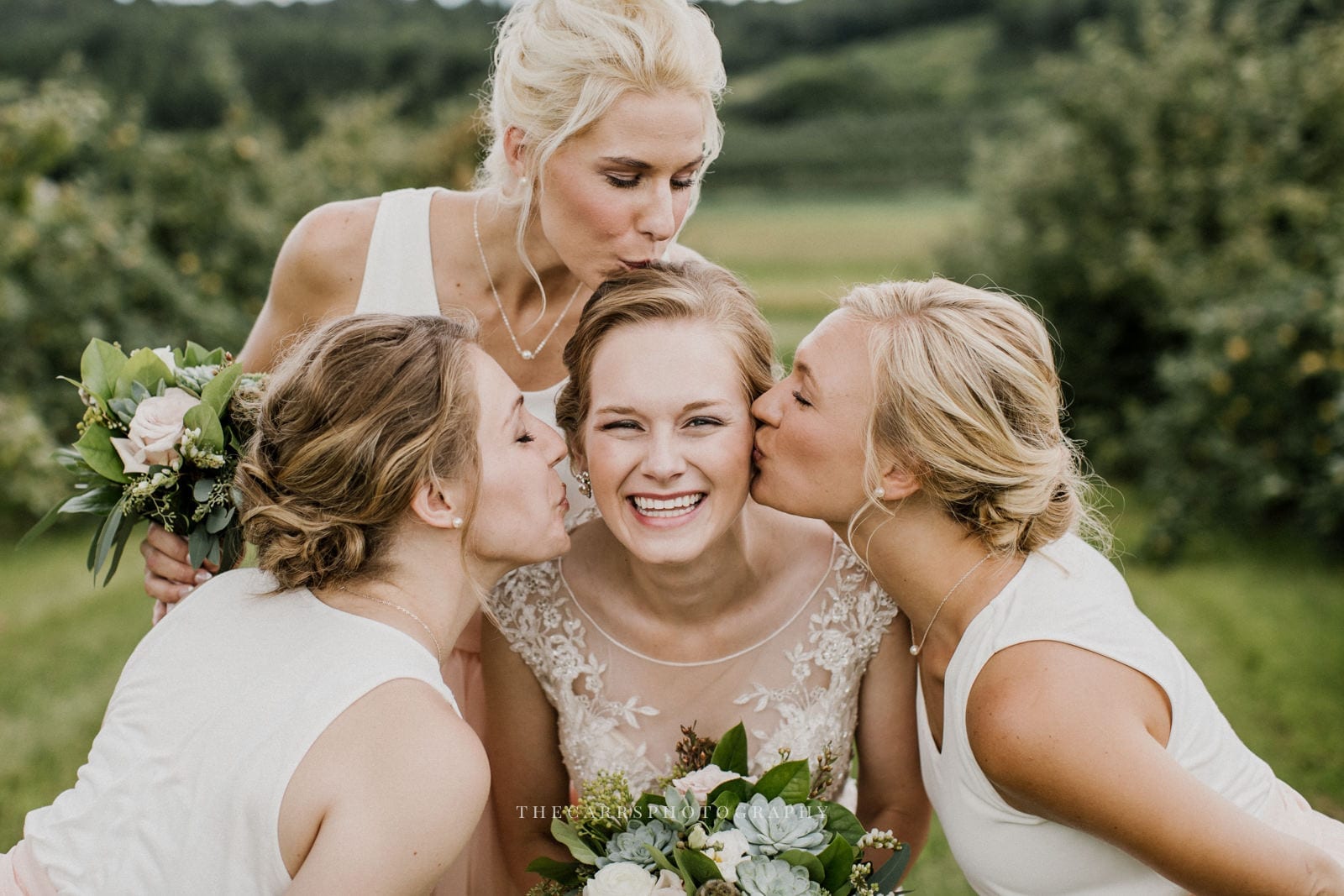bridesmaids kiss bride at Eckers Apple Farm Wedding - Destination Photographer