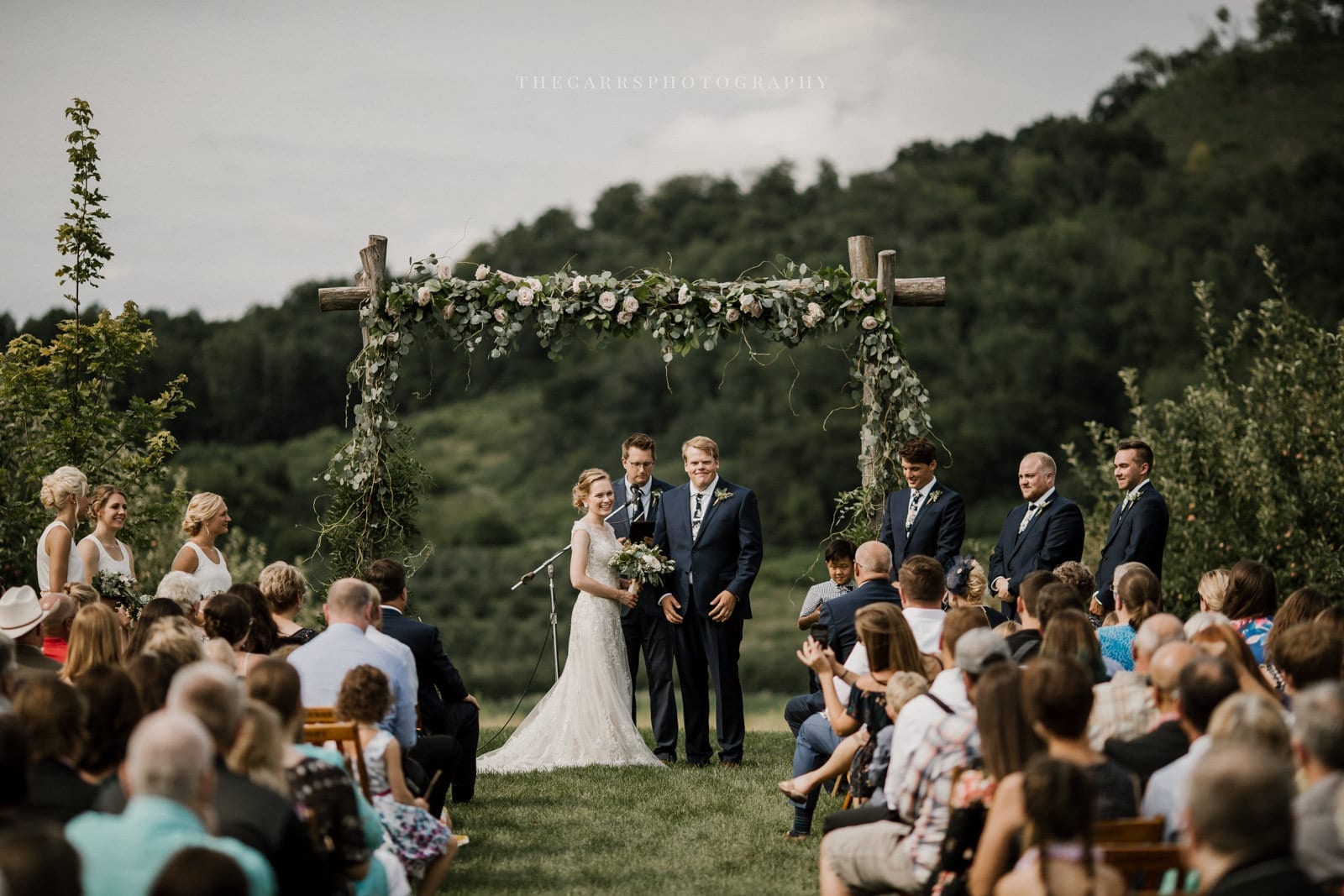 bride and groom at alter arch at Eckers Apple Farm Wedding - Destination Photographer