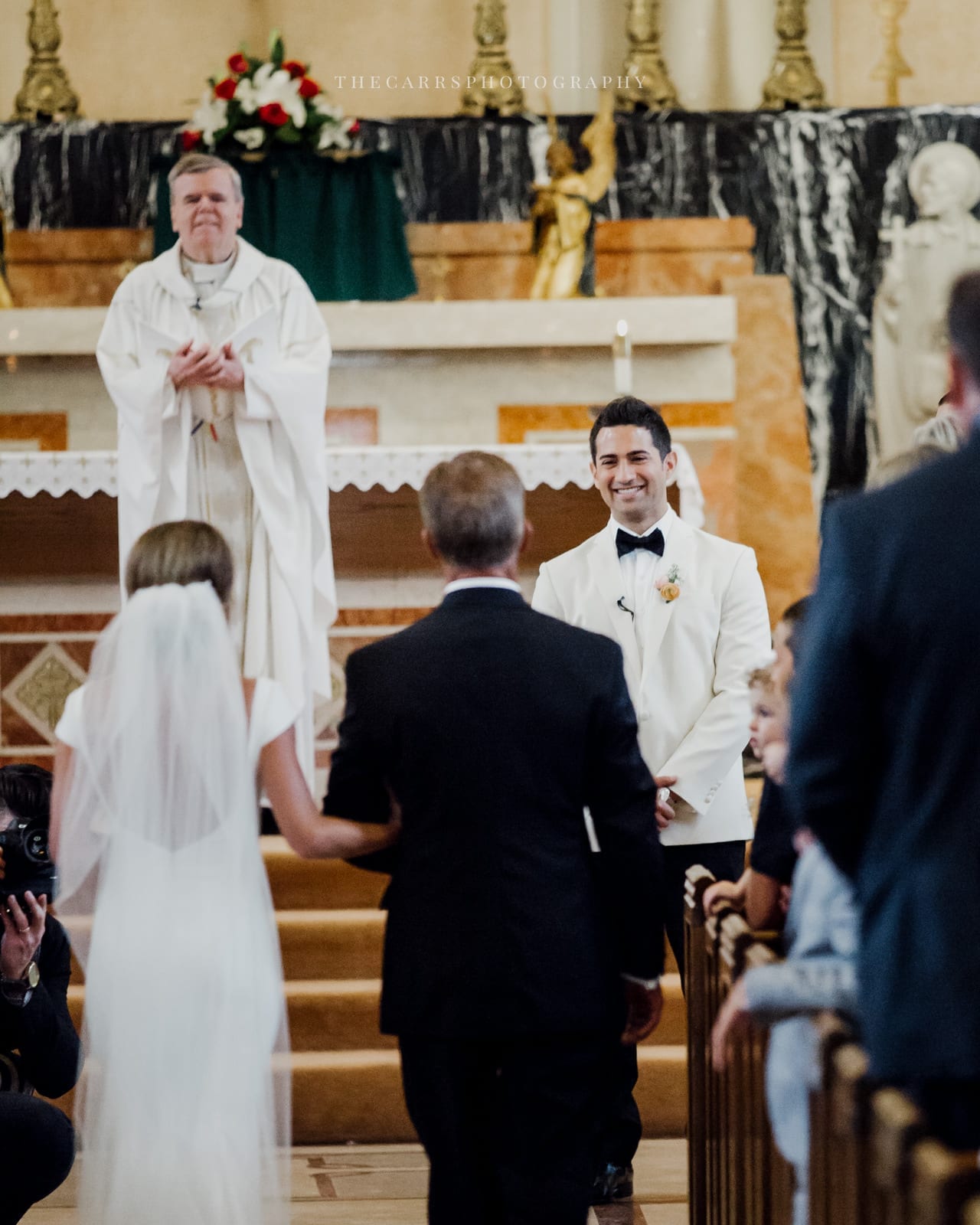 groom smiles as bride walks down the aisle at lake house wedding - Akron Ohio Wedding Photographer