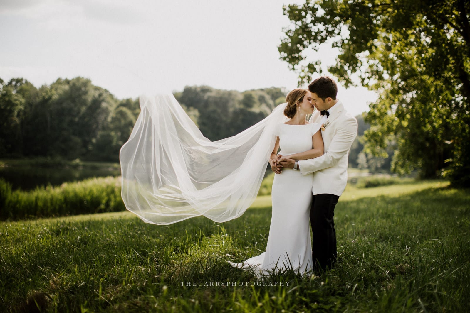 bride and groom kiss brides veil blows Iat lake house wedding - Akron Ohio Wedding Photographer