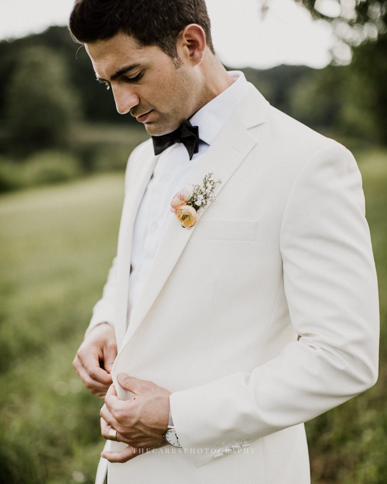 groom adjusts coat at lake house wedding - Akron Ohio Wedding Photographer