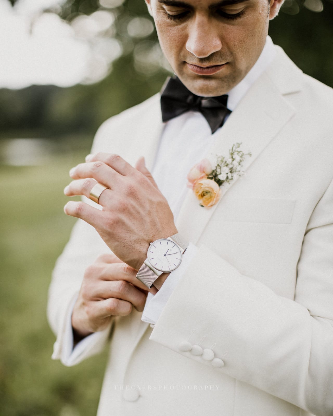 groom adjusts watch at lake house wedding - Akron Ohio Wedding Photographer