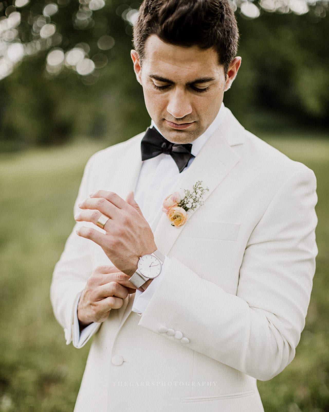groom adjusts watch at lake house wedding - Akron Ohio Wedding Photographer