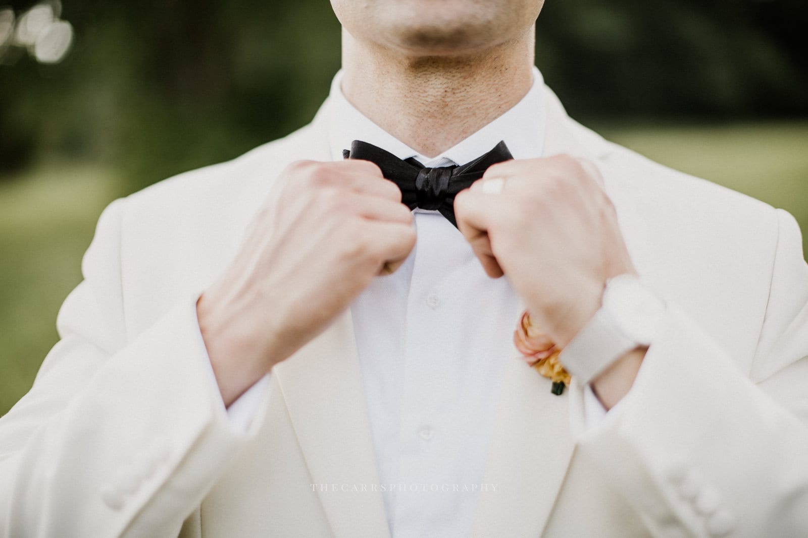 close up of groom adjusting tie at lake house wedding - Akron Ohio Wedding Photographer
