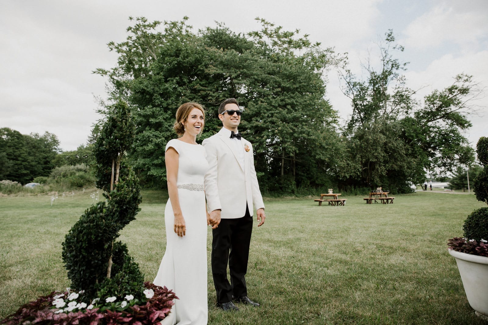 bride and groom hold hands at lake house wedding - Akron Ohio Wedding Photographer