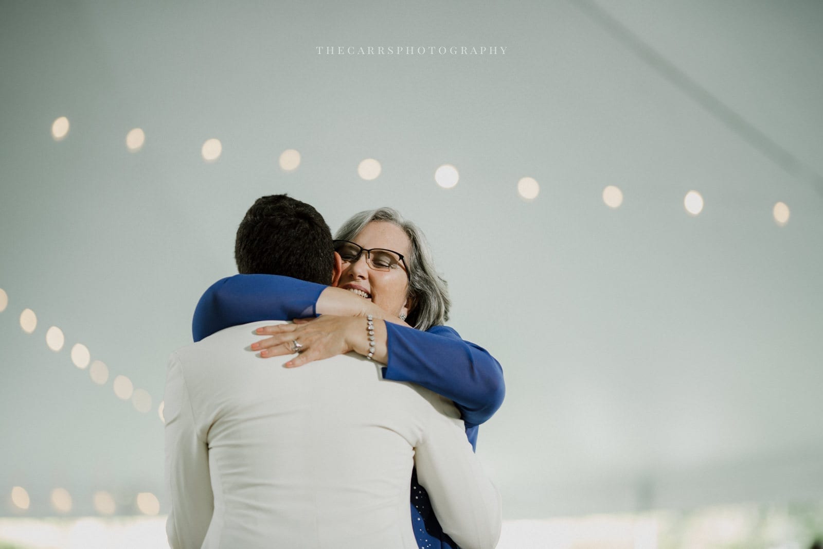 groom hugs mom at lake house wedding - Akron Ohio Wedding Photographer