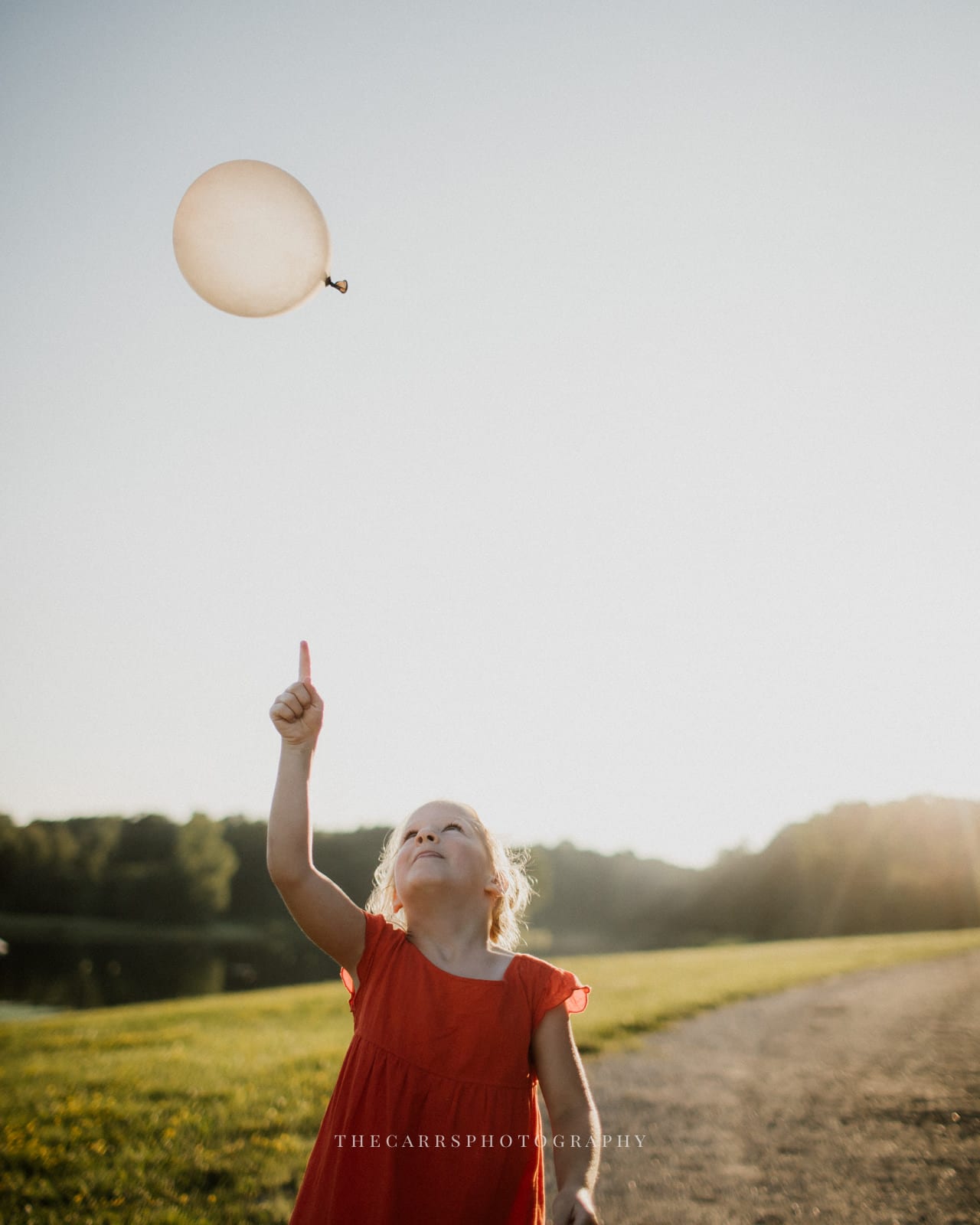 child points to floating balloon at lake house wedding - Akron Ohio Wedding Photographer