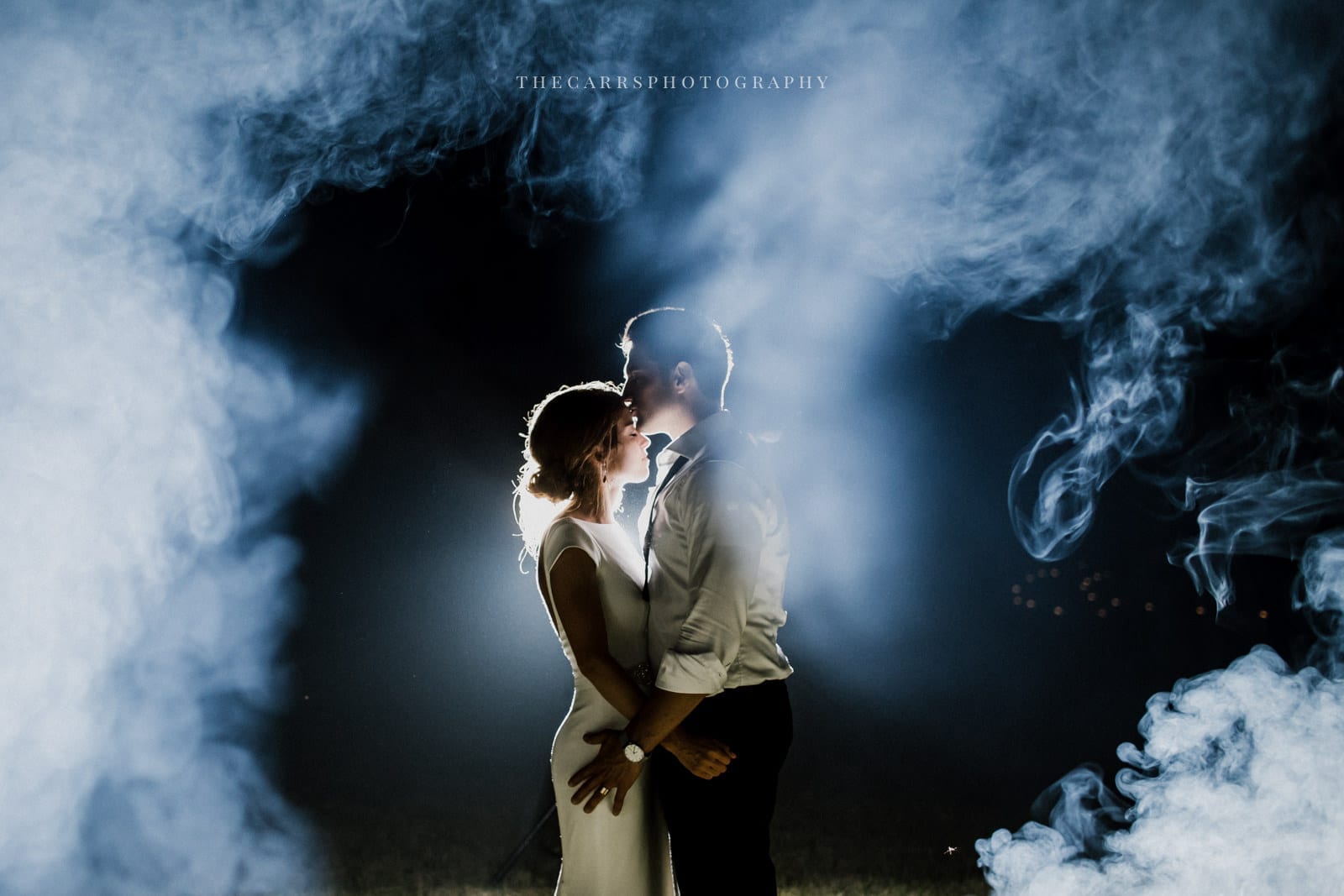 bride adn groom kissing in smoke at lakehouse wedding - Akron Ohio Wedding Photographer