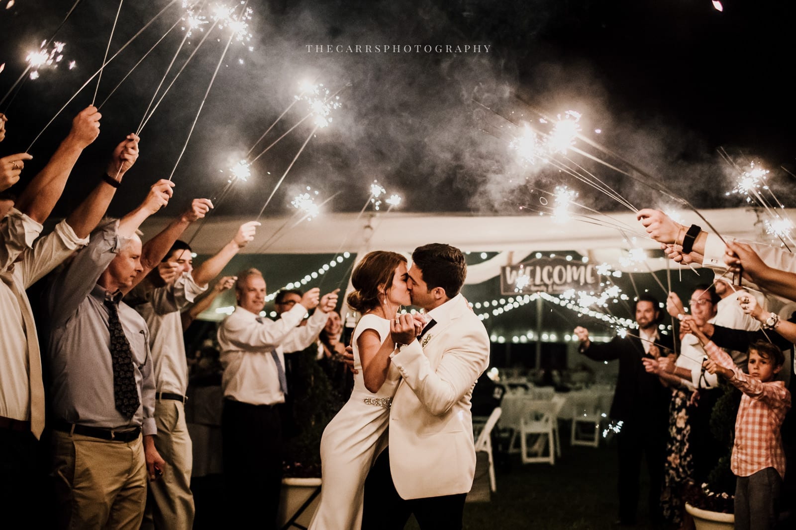 bride and groom kiss under sparklers at lakehouse wedding - Akron Ohio Wedding Photographer