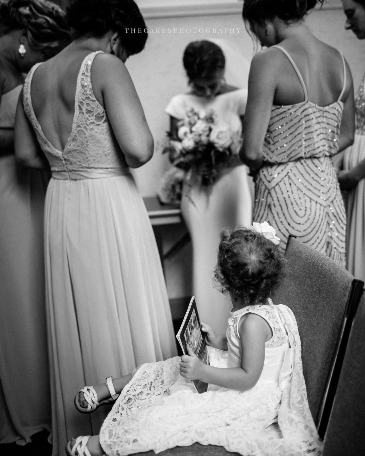 flower girl watches bride and bridesmaids pray at lake house wedding - Akron Ohio Wedding Photographer