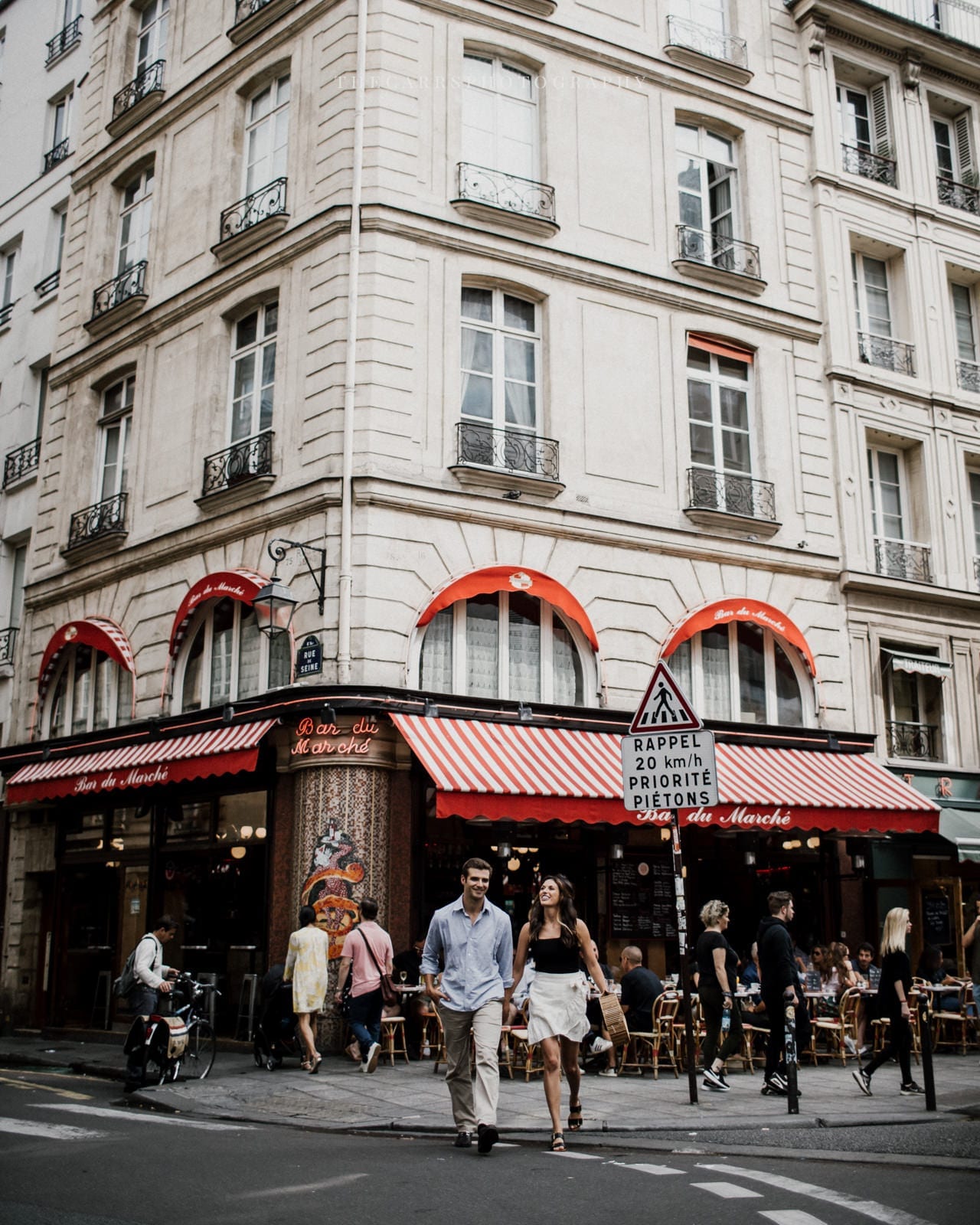 couple walks in Parisian street by Paris Engagement Photographer