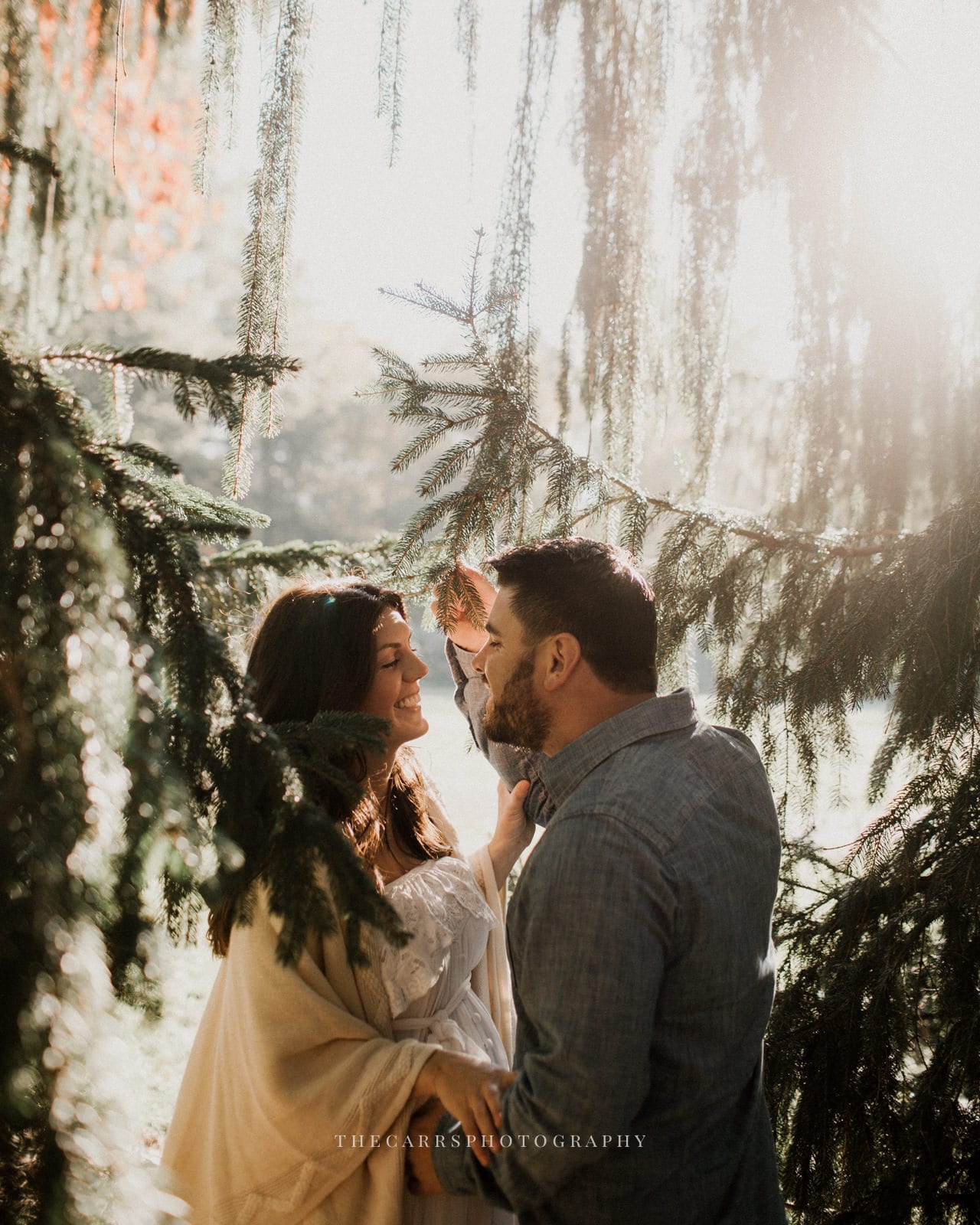 husband and wife laughing in trees - dayton ohio maternity photographer