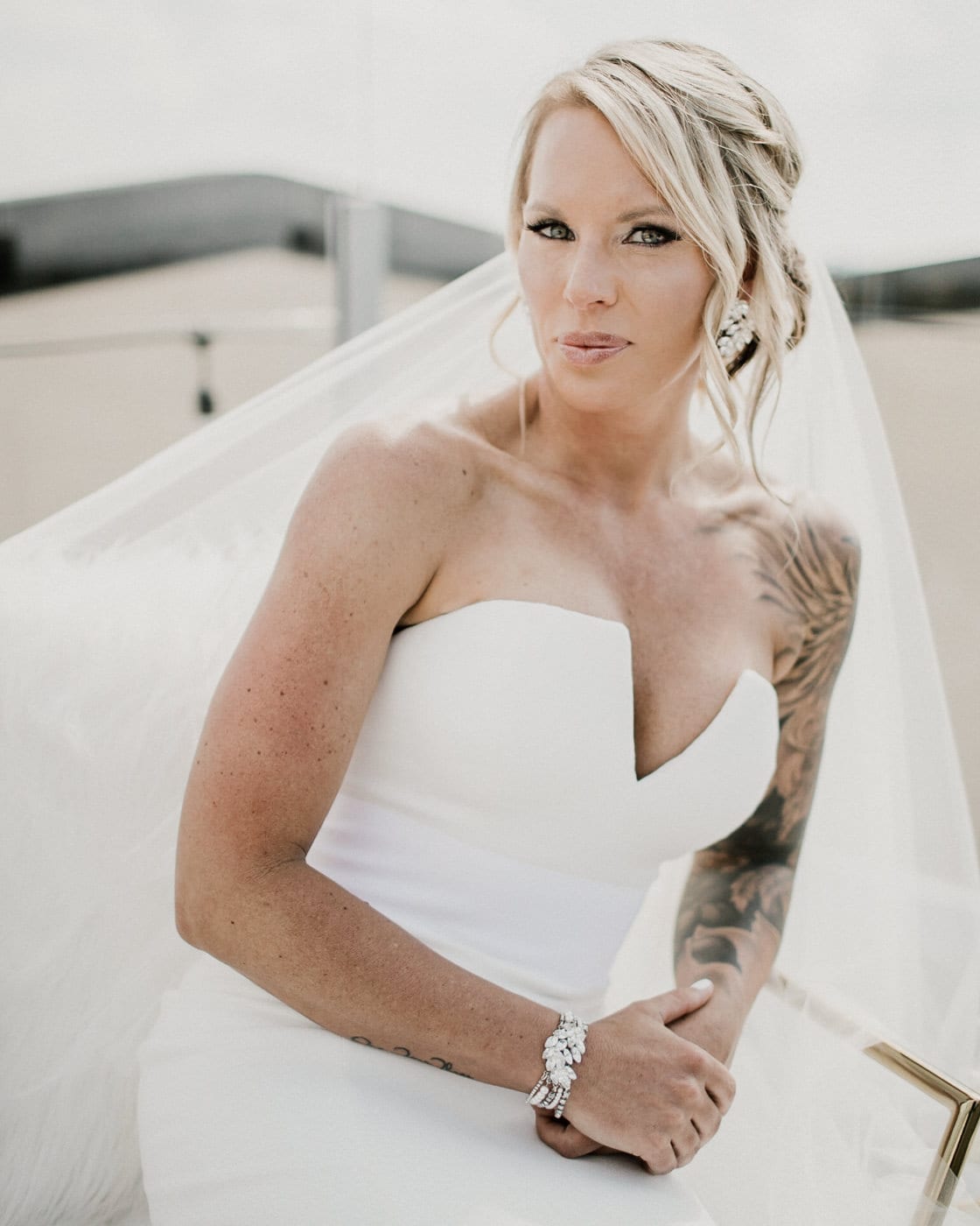 portrait of bride leaning on railing at Juniper Rooftop Wedding