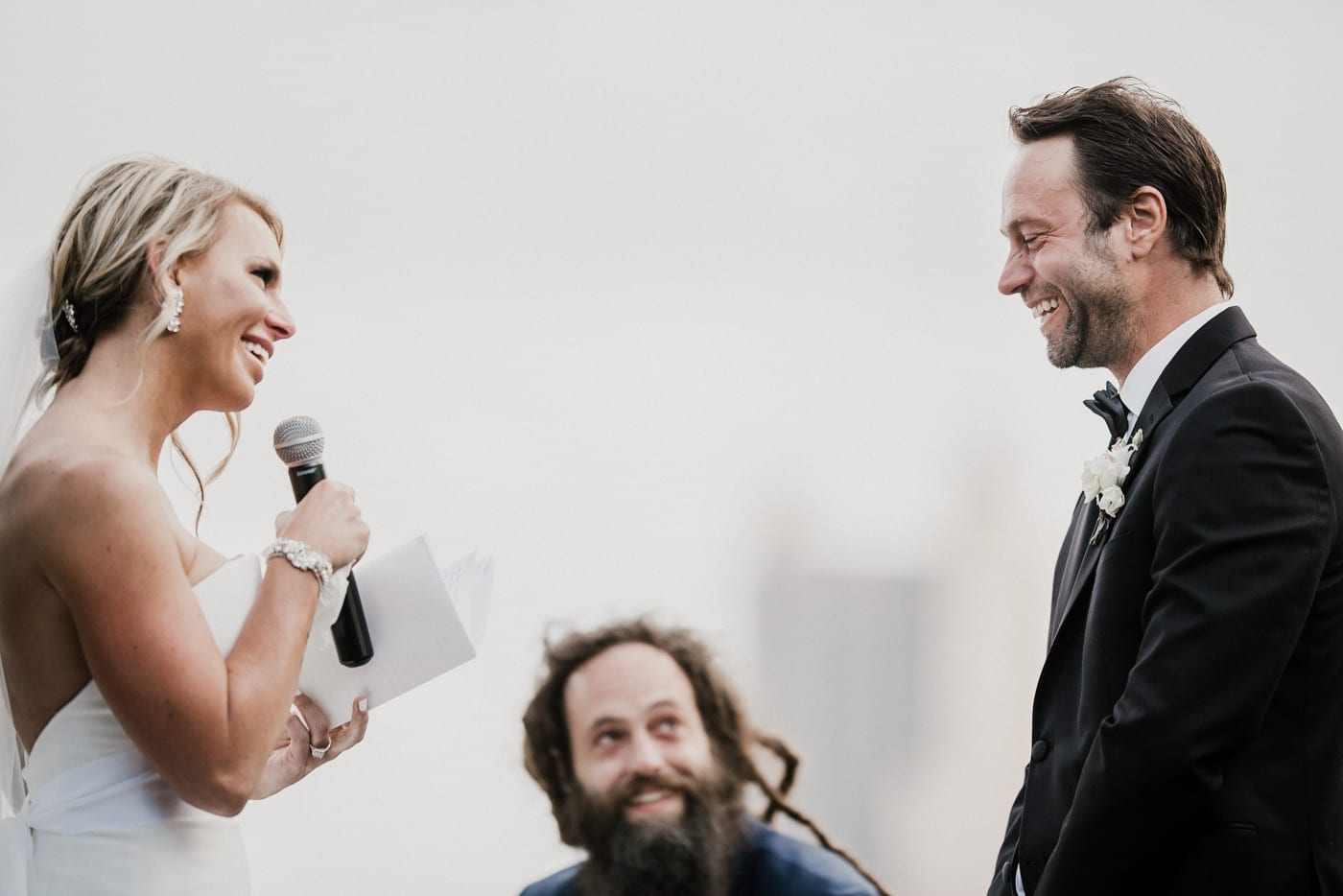 bride looks at grooms while saying vows at Juniper Rooftop Wedding