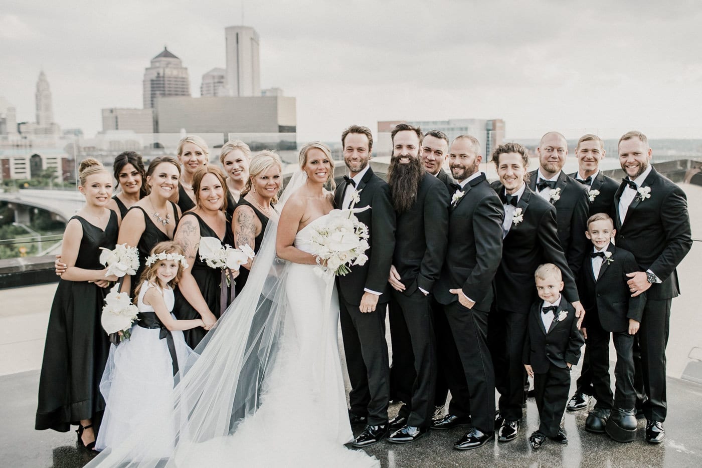 bride groom and bridal party smiling at Juniper Rooftop Wedding