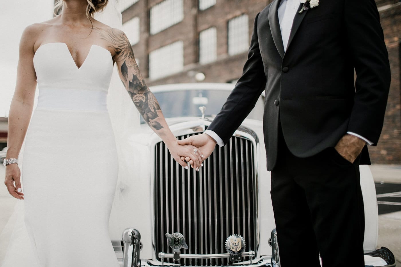 bride and groom holding hands in front of vintage white car at Juniper Rooftop Wedding