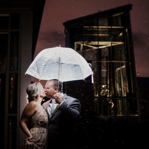 couple kisses under umbrella by Dayton Ohio Photographer Kera Estep
