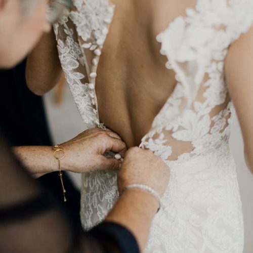 Bride's dress is buttoned by her mother by Dayton Ohio Photographer Kera Estep