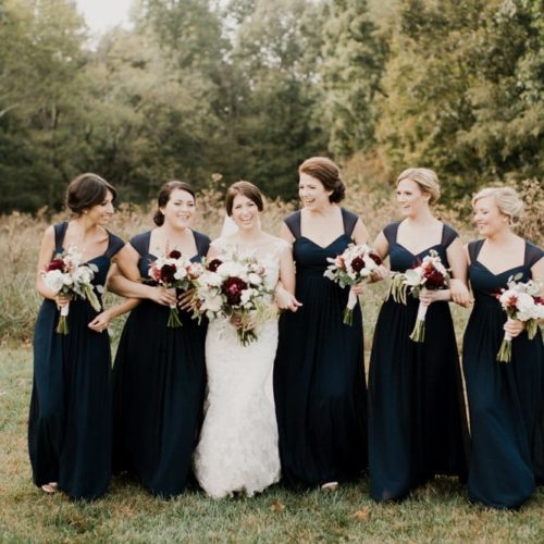 Bride and Bridesmaids smile and walk in outdoor wedding by Dayton Ohio Photographer Kera Estep