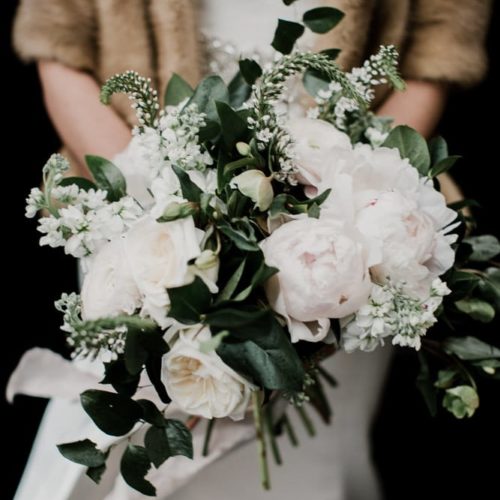 Bride holds bouquet in fur coat by Dayton Ohio Photographer Kera Estep