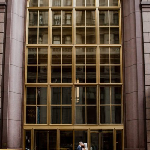 couple kisses in front of large urban building by Dayton Ohio Photographer Kera Estep
