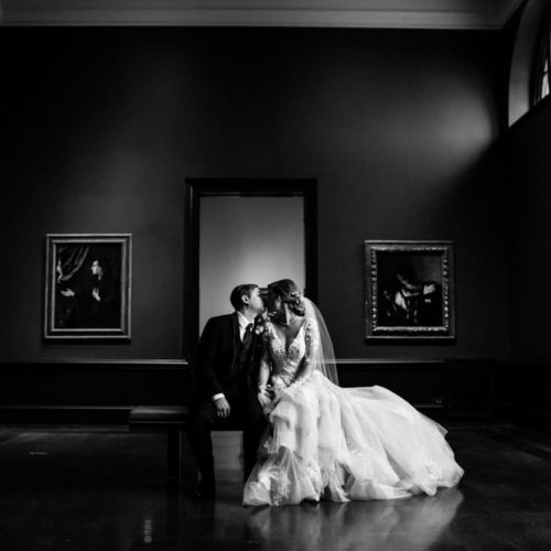 bride and groom kiss in front of works of art by Dayton Ohio Photographer Kera Estep