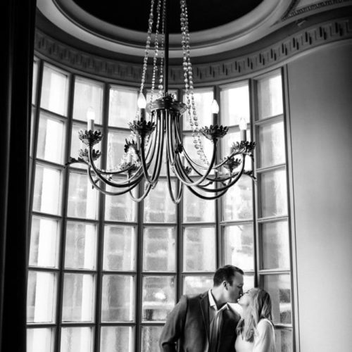 bride and groom kiss under ornate chandelier by Dayton Ohio Photographer Kera Estep