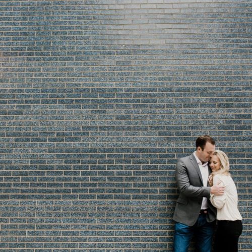 couple embraces in front of brick wall by Dayton Ohio Photographer Kera Estep