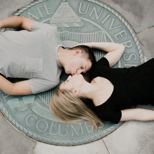 couple kisses on university seal by Dayton Ohio Photographer Kera Estep