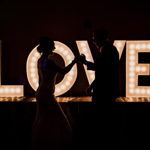 bride and groom dance in front of love sign by Dayton Ohio Photographer Kera Estep