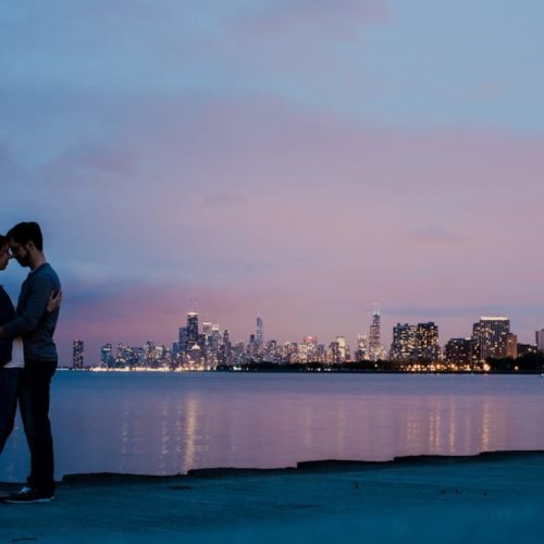 couple embracing at sunset with city skyline in the background by Dayton Ohio Wedding Photographer Josh Ohms