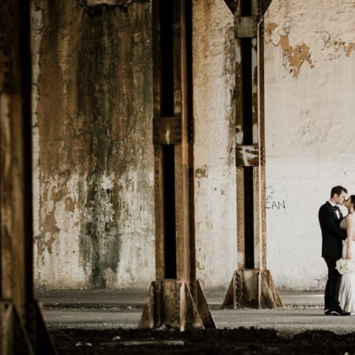 bride and groom kissing in empty warehouse by Dayton Ohio Wedding Photographer Josh Ohms