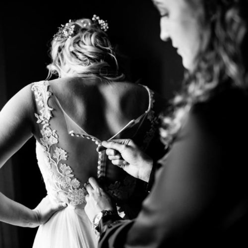 bride getting buttoned up by Dayton Ohio Wedding Photographer Josh Ohms