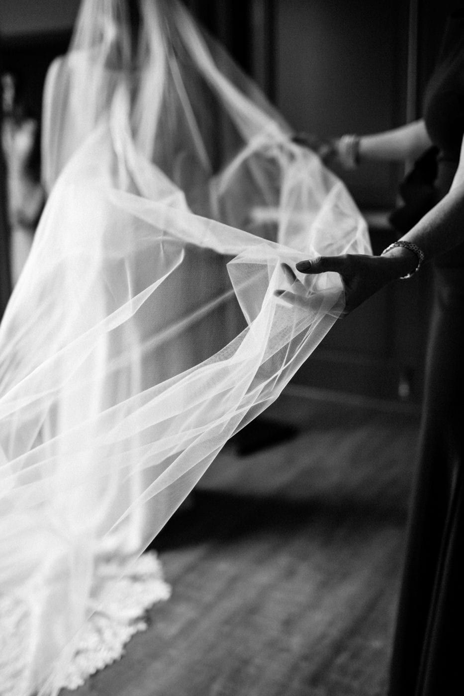 brides mom holds out veil at black tie winter wedding