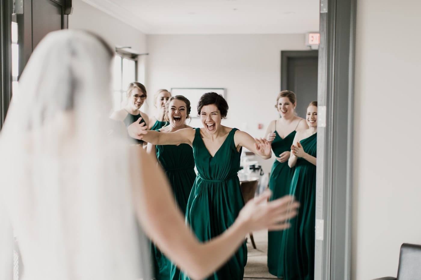 bridesmaids react to seeing bride for first time at black tie winter wedding