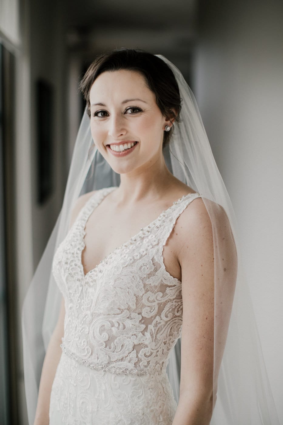 bride smiling in lace dress at black tie winter wedding