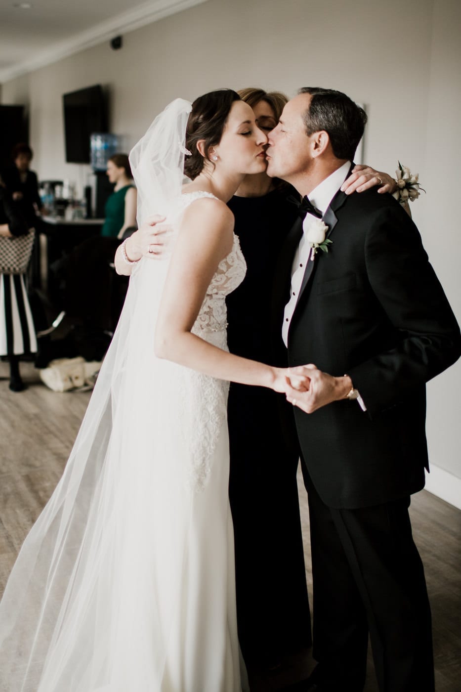 bride kisses family at black tie winter wedding