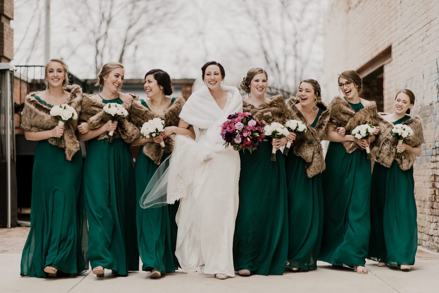 bride and bridesmaids laughing and talking at black tie winter wedding