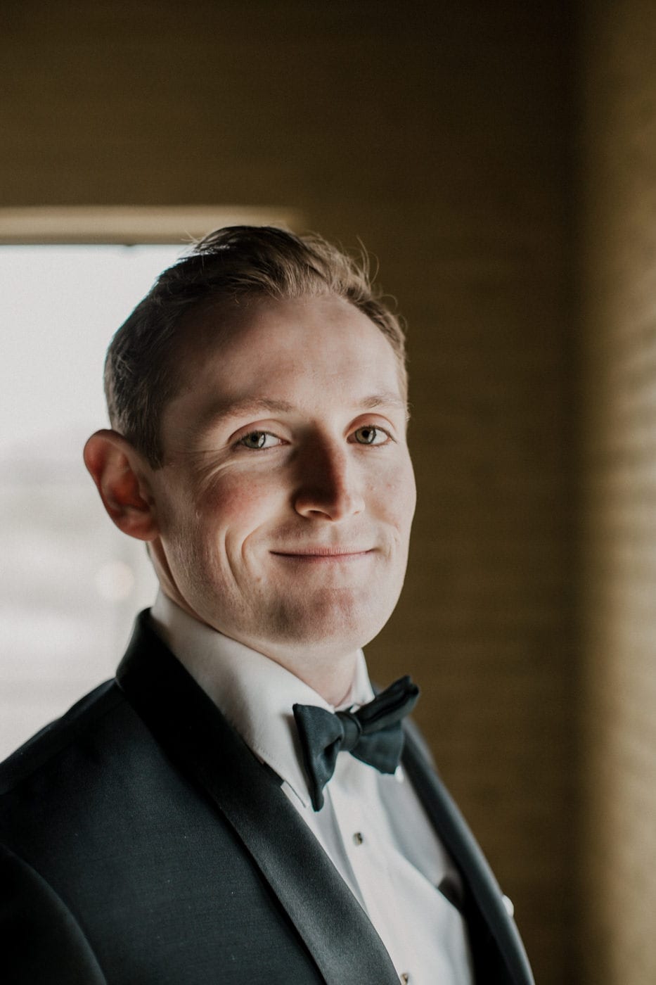 close up of groom smiling at black tie winter wedding
