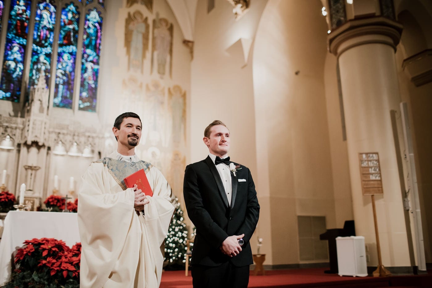groom waits for bride at front of church at black tie winter wedding